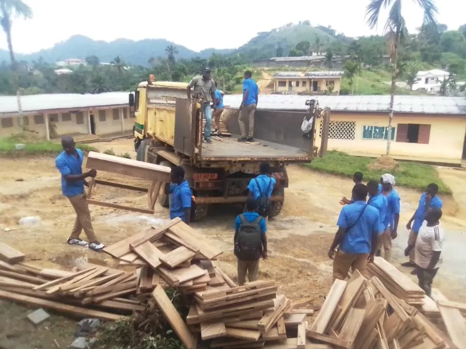 Pupils unloading new desks from a truck at the Ngonga school